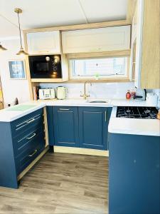 a kitchen with blue cabinets and a sink at The Hideaway in Scarborough