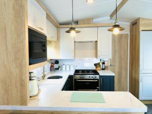 a kitchen with white cabinets and a stove top oven at The Hideaway in Scarborough