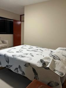 Un dormitorio con una cama con una manta. en El hogar de Olguita 2, en Tarapoto
