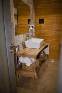 a bathroom with a white sink on a wooden counter at Cabana AFrame Olanesti in Băile Olăneşti