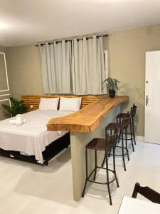 a bedroom with a bed and a table and chairs at Jr FLATS in João Pessoa
