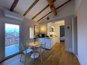 Zimmer mit einem Tisch und einer Küche mit Aussicht in der Unterkunft Romantic attic room with panoramic view in Bologna