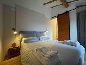 1 dormitorio con 1 cama grande y toallas. en Romantic attic room with panoramic view en Bolonia
