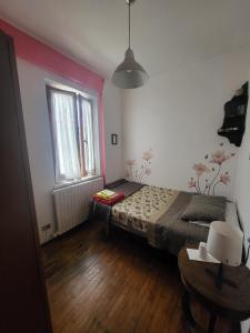 a bedroom with a bed and a table and a window at A CASA DI NONNA LUISA in Porto San Giorgio