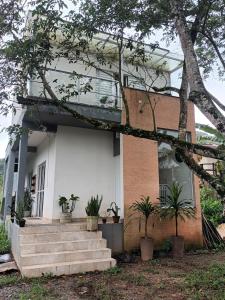a house with stairs and potted plants in front of it at Chalés Cambury in Camburi +11 photos