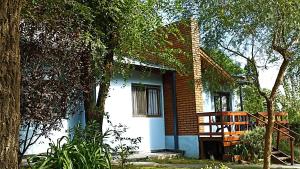 聖羅莎德克蘭穆齊塔的住宿－siete colores，一个小房子,有门廊和一棵树