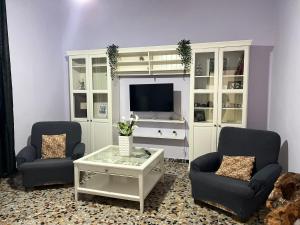 sala de estar con 2 sillas y TV en L'Oasi del Cervo, en Florencia