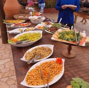 ein Tisch mit vielen Teller Essen drauf in der Unterkunft Quartos simples e aconchegantes na orla de Itaparica in Itaparica Town