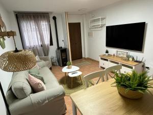 uma sala de estar com um sofá e uma mesa em ALOJAMIENTO RURAL EL CASTAÑO em Fuenteheridos