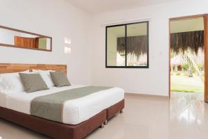 a white bedroom with a bed and a window at Hukumeizi Hotel in Palomino