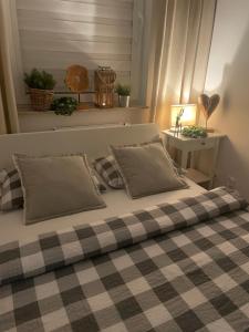 un letto con coperta e cuscini a scacchi di Apartament Stella Park a Stargard