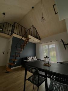 a dining room with a table and a spiral staircase at Domek u Gołąbków Bieszczady in Lesko