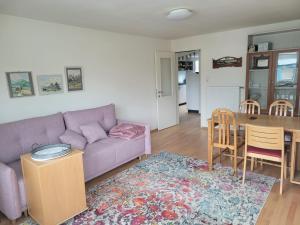 sala de estar con sofá púrpura y mesa en Ferienwohnung Dornbirn City, en Dornbirn