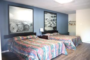 een hotelkamer met 2 bedden en een schilderij aan de muur bij Hotel O Oskaloosa - Hwy 63/92 in Oskaloosa