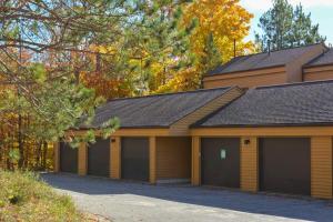 a house with four garage doors in a driveway at Trout Creek Resort Condo - 1 Mi to Nubs Nob! in Harbor Springs