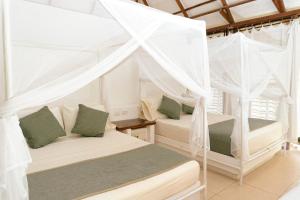 two beds in a room with white drapes at Hukumeizi Hotel in Palomino