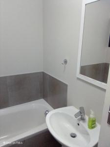 een witte badkamer met een wastafel en een bad bij Waterfall Ridge Apartments - Kick back and Relax in Midrand