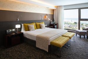 een hotelkamer met een groot bed en een groot raam bij Hotel Uthgra Sasso in Mar del Plata