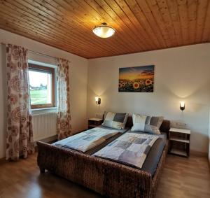 1 dormitorio con 1 cama grande y techo de madera en Ferienwohnung mit 3 Schlafzimmern Hartl Hof, en Breitenberg