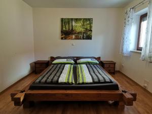 duże łóżko w pokoju z drewnianą podłogą w obiekcie Ferienwohnung mit 3 Schlafzimmern Hartl Hof w mieście Breitenberg