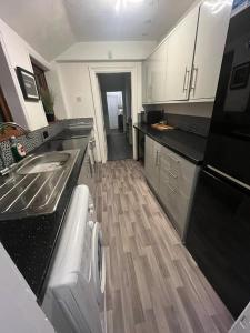 uma cozinha com um lavatório e uma máquina de lavar louça em Large 3 Bed House, 2 Bathrooms em Ilkeston