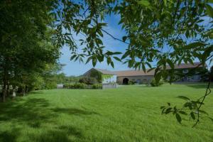 a field of green grass with a building in the background at Domaine de Godchure - Gîte & Spa 
