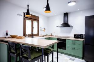 una cocina con armarios verdes y una mesa con sillas en Casa Rural Lucero, en Hita