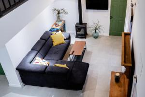 Casa Rural Lucero في Hita: غرفة معيشة مع أريكة سوداء وطاولة