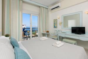 Schlafzimmer mit einem Bett und Meerblick in der Unterkunft Hotel Timoleon in Limenas