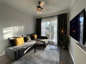 a living room with a couch and a large window at Central Welling Flat in Welling