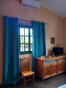 a bedroom with blue curtains and a desk and a window at Vivienda vacacional Casa Rosi in Frontera