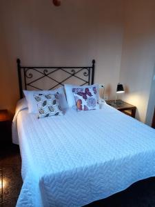a large bed with white sheets and pillows on it at Vivienda vacacional Casa Rosi in Frontera