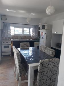 uma cozinha com uma mesa com cadeiras e um frigorífico em ENCANTO SERRANO em Villa Carlos Paz