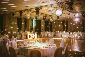 a banquet hall with white tables and chairs and chandeliers at Hotel Uthgra Sasso in Mar del Plata +41 photos