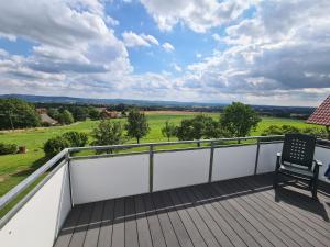 balcón con silla y vistas a un campo en Moderne Ferienwohnung mit Aussicht, en Bad Oeynhausen