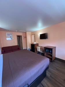 a hotel room with a large bed and a desk at Executive Inn & Suites Near Lackland AFB in San Antonio