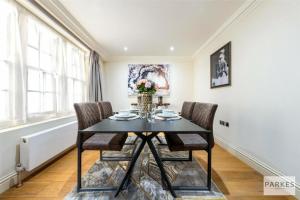 a dining room with a black table and chairs at Shepherd Street, Mayfair in London