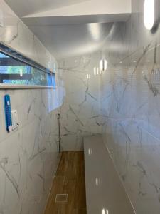 a bathroom with white marble walls and a sink at Chalé Alto da Serra - Pousada & Wellness Spa in São Joaquim