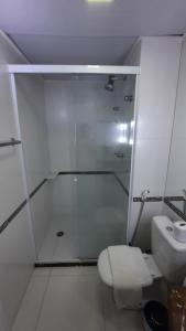 a white bathroom with a shower and a toilet at Flat Hotel av Macuco São Paulo Ibirapuera UH-2710 in São Paulo