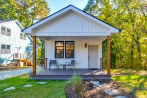 ein kleines weißes Haus mit einem Tisch und Stühlen auf einer Veranda in der Unterkunft Durham Vacation Rental 1 Mi to Duke University! in Durham