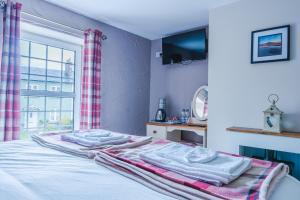 sypialnia z łóżkiem z ręcznikami w obiekcie The Cock Hotel w mieście Bronllys