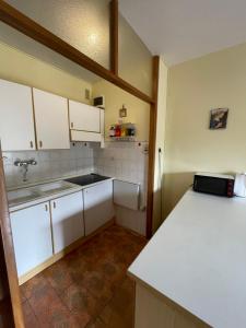 a kitchen with white cabinets and a counter top at Casa Anna - Andalo centrale sugli impianti da sci in Andalo