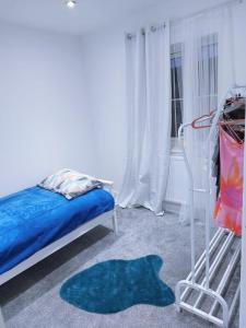 sypialnia z łóżkiem i niebieskim dywanem w obiekcie Cosy Family Home in Long Eaton, Nottingham w Nottingham