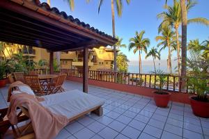 a patio with a bed and a table and chairs at Hermoso alojamiento en los Tules, frente al mar en medio de hermosos jardines, es Unico!!! in Puerto Vallarta