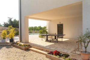 a patio with a ping pong table and plants at Villa Elani - Stylish And Modern 6B Seaview Villa in Vrsi