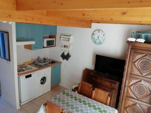 una piccola cucina con lavandino e forno a microonde di Appartement type chalet 2 chambres avec terrasse a Cauterets