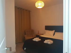 um quarto com uma cama e uma cadeira com toalhas em Mar y Sol Suites em Grao de Castellón