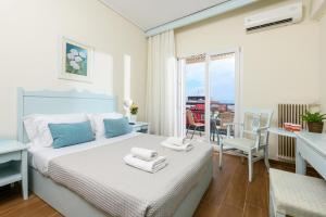 Hotel Timoleon في لايميناس: غرفة نوم عليها سرير وفوط