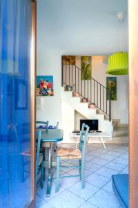 a dining room with a table and chairs and a staircase at Villa Aura in Marina di Modica