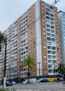 a large building with a bus parked in front of it at Apto frente Praia Itararé in São Vicente